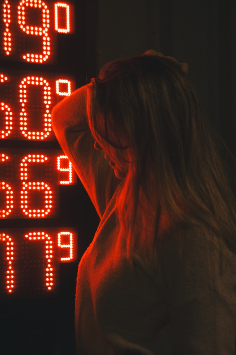 Woman in front of glowing red digital numbers